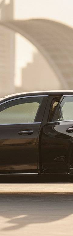 Luxury limousine parked outside a Dubai hotel entrance at dusk
