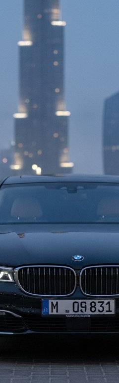 Chauffeur opening a luxury sedan door for an executive in Dubai